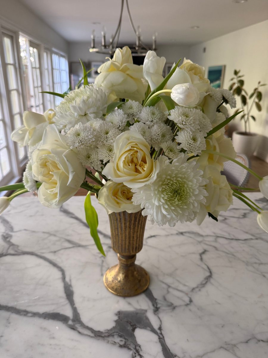 White rose, tulip and chrysanthemum centerpiece in a gold footed vase